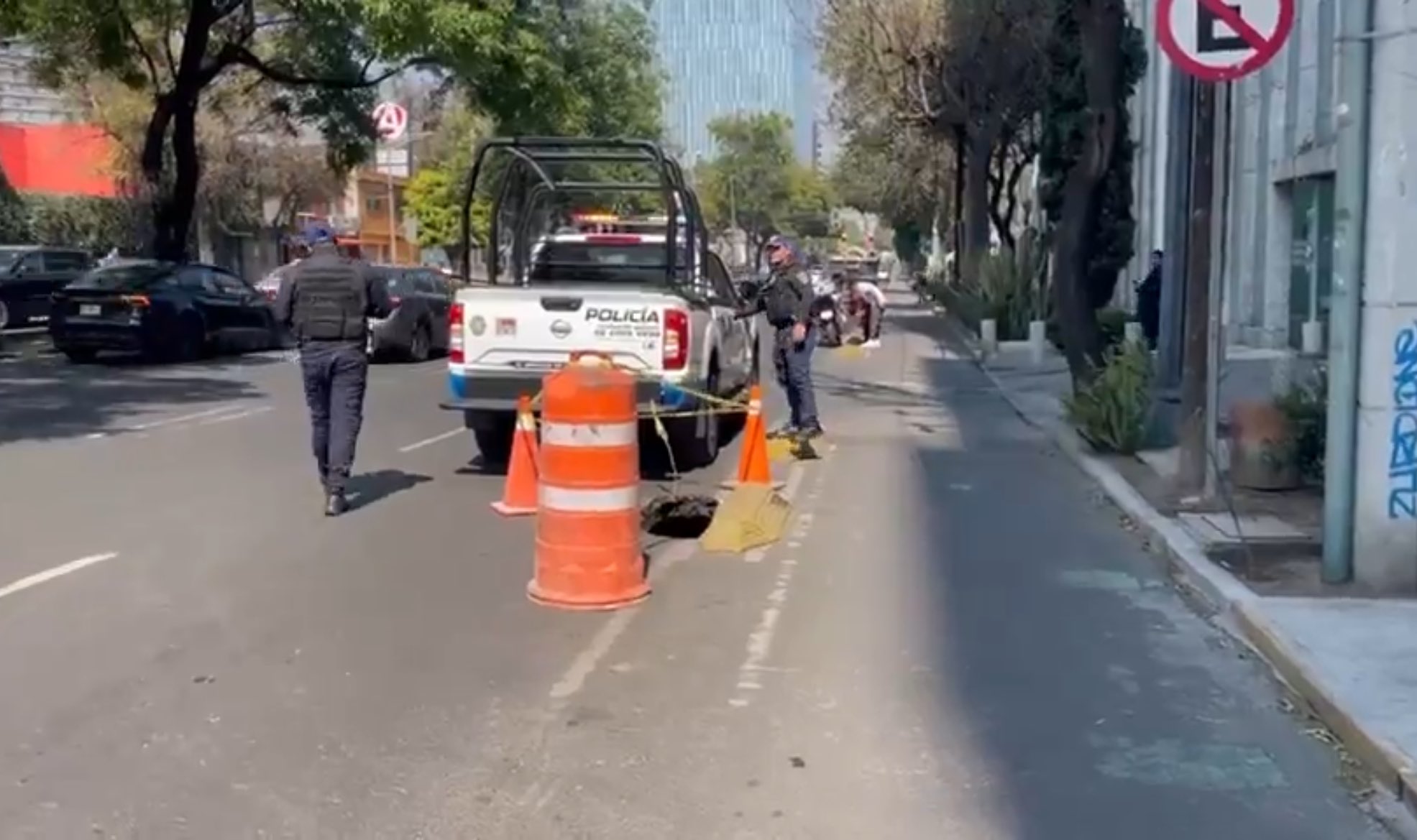 Policía acordonando socavón en avenida principal de la Ciudad de México